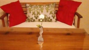 a bench with two red pillows and a flower on it at Casa Rural "La Posada de María" in Malpartida de Cáceres