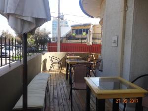 een patio met tafels en stoelen en een parasol bij Sentir Patagonia in Viña del Mar
