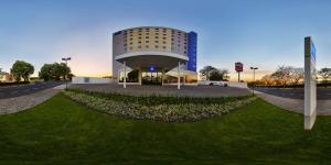 a building with a grassy field in front of it at ibis budget Sao Jose do Rio Preto in Sao Jose do Rio Preto