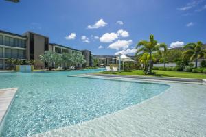 a swimming pool with blue water in front of a building at Blue on Blue Apartment 813 in Nelly Bay
