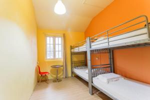 a room with three bunk beds and a table at The Hive Singapore Hostel in Singapore +31 photos