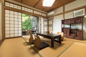 uma sala de estar com mesa e cadeiras em Miyajima Guest House Mikuniya em Miyajima