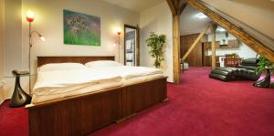 - une chambre avec un grand lit et un tapis rouge dans l'établissement Brioni Suites, à Ostrava