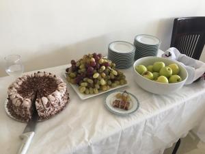 a table with a cake and a bowl of fruit at Taybeh Golden Hotel in Ramallah