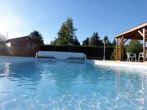 ein großer Pool in einem Hof mit einem Haus in der Unterkunft La Campagnarde in Saint-Just-en-Chevalet