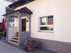 einen Eingang zu einem Haus mit einer Tür und Blumen in der Unterkunft Casa Christina in Orschweier