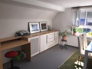 Zimmer mit einem Schreibtisch, einem Tisch und einigen Fenstern in der Unterkunft Casa Christina in Orschweier