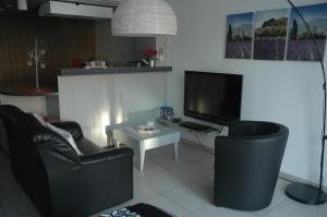 ein Wohnzimmer mit 2 Stühlen und einem Flachbild-TV in der Unterkunft Studio De Zunneblomme in Middelkerke