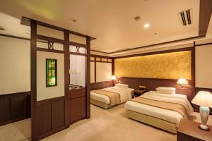 a hotel room with two beds and a bathroom at Kanazawa Hakuchoro Hotel Sanraku -Natural Hot Spring- in Kanazawa