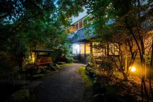 un camino delante de un edificio por la noche en Yufuin Besso Shikisai Hotel, en Yufu