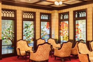 a row of chairs in a room with stained glass windows at Kanazawa Hakuchoro Hotel Sanraku -Natural Hot Spring- in Kanazawa