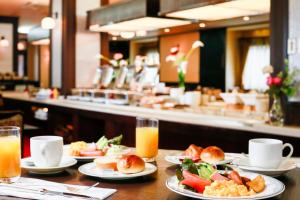 Kanazawa Hakuchoro Hotel Sanraku في كانازاوا: طاولة مليئة بأطباق الطعام وعصير البرتقال