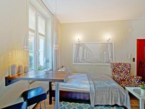 a room with a bed and a table and a chair at Apartament Kameralny V in Gdańsk