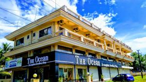 un gran edificio amarillo con un cartel para la ópera en Ocean Crest Hotel, en Colva