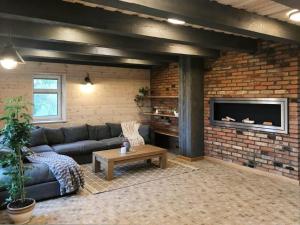 a living room with a couch and a brick wall at Aitvaras in Anykščiai