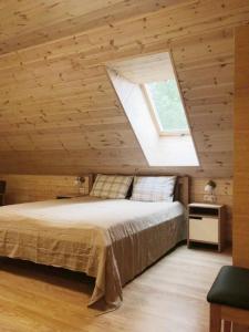 a bedroom with a large bed with a skylight at Aitvaras in Anykščiai