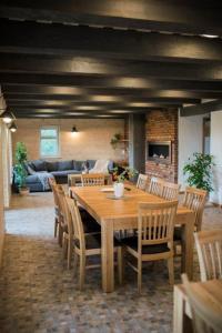 a dining room with a wooden table and chairs at Aitvaras in Anykščiai