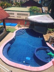 una gran piscina azul con un edificio en el fondo en The Billabong Guesthouse, en Kampot