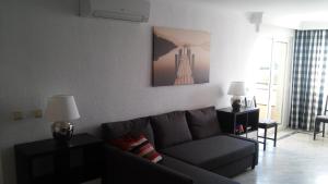 a living room with a gray couch in a room with a window at Apartamento El Coloso 4Q in Benalmádena