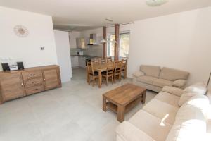 ein Wohnzimmer mit einem Sofa und einem Tisch in der Unterkunft Villapark Lipno Dreams in Lipno nad Vltavou