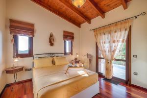 a bedroom with a bed and a large window at Villa Russelia in Kalavárda