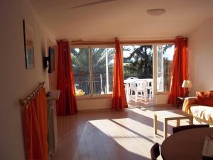 a living room with red curtains and a view of a patio at Appartamento con vista sul Golfo in Lerici
