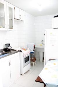 cocina blanca con fregadero y fogones en Lapa fácil mobilidade no Rio ap 2 quartos, en Río de Janeiro