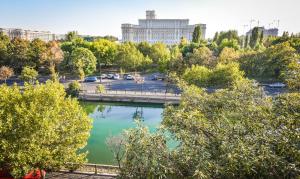 Blick auf einen Fluss in einer Stadt mit Bäumen in der Unterkunft Parliament & River View Apartments in Bukarest