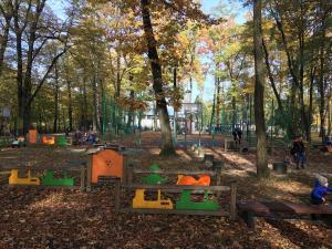 a park with trees and benches and people in it at Apartamenty Nad Potoczkiem in Ustroń +10 photos