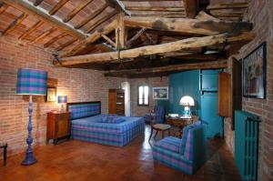 ein Wohnzimmer mit blauen Möbeln und einer Ziegelwand in der Unterkunft Castello Delle Quattro Torra in Siena