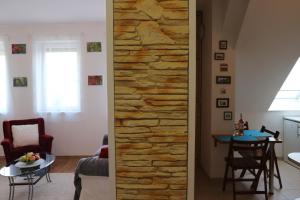 a living room with a stone wall at Éger Apartman in Eger