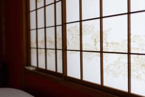 uma janela com vista para uma árvore na neve em Copain Kurumi em Kanazawa