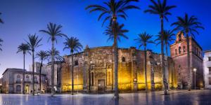 un antiguo edificio con palmeras delante en Casa Miraya, en Almería