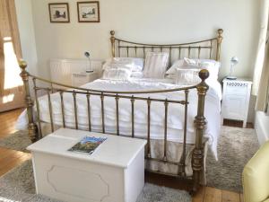 1 dormitorio con 1 cama con sábanas blancas y mesa en Cliftonville House, en Whitstable