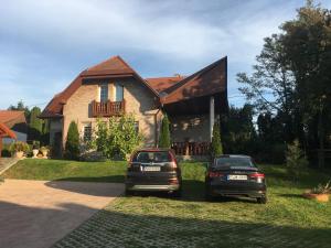 two cars parked in front of a house at Gabi Magánszálláshely in Zalasárszeg