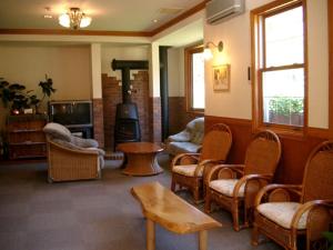 a living room with chairs and a wood stove at Pension Come in Minami Uonuma