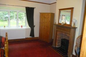 uma sala de estar com lareira e 2 janelas em The Ramblers Retreat em Abergele