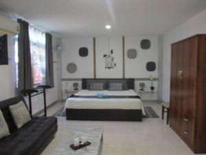 a large bedroom with a bed and a couch at Similan Hotel in Bang Tao Beach