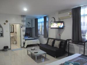 a living room with a couch and a tv at Similan Hotel in Bang Tao Beach