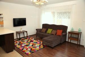 a living room with a couch and a rug at Rozmaring Pihenőház in Velence