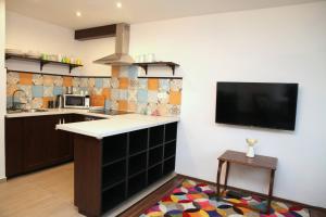 a kitchen with a counter and a tv on the wall at Rozmaring Pihenőház in Velence