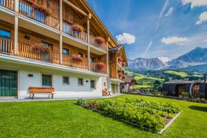 a building with a bench next to a green yard at Apt Bel Pre in La Villa