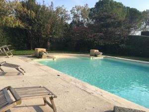 una piscina con panchina e sedia di Le mazet du château a Fontvieille