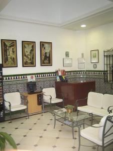a waiting room with white chairs and a desk at Pension Gala in Seville