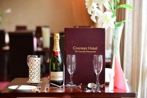 a bottle of champagne and two glasses on a table at Cooneys Hotel in Ballymahon