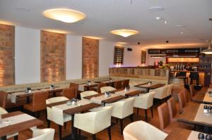 ein Restaurant mit Holztischen und -stühlen und einer Bar in der Unterkunft Hotel Traube in Zell am See