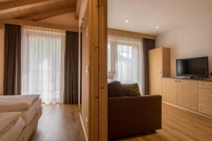 een hotelkamer met een bank en een televisie bij Apt Bel Pre in La Villa