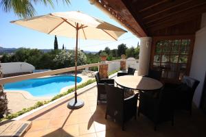 patio con tavolo, ombrellone e piscina di Can Alinda a Santa Eularia des Riu
