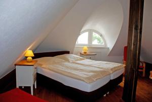 Schlafzimmer mit einem Bett und einem Fenster in der Unterkunft Karolas Landhus unterm Reetdach in Neu Reddevitz