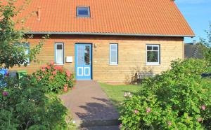 a house with an orange roof and a blue door at Ferienwohnung in Gustow in Gustow +9 photos